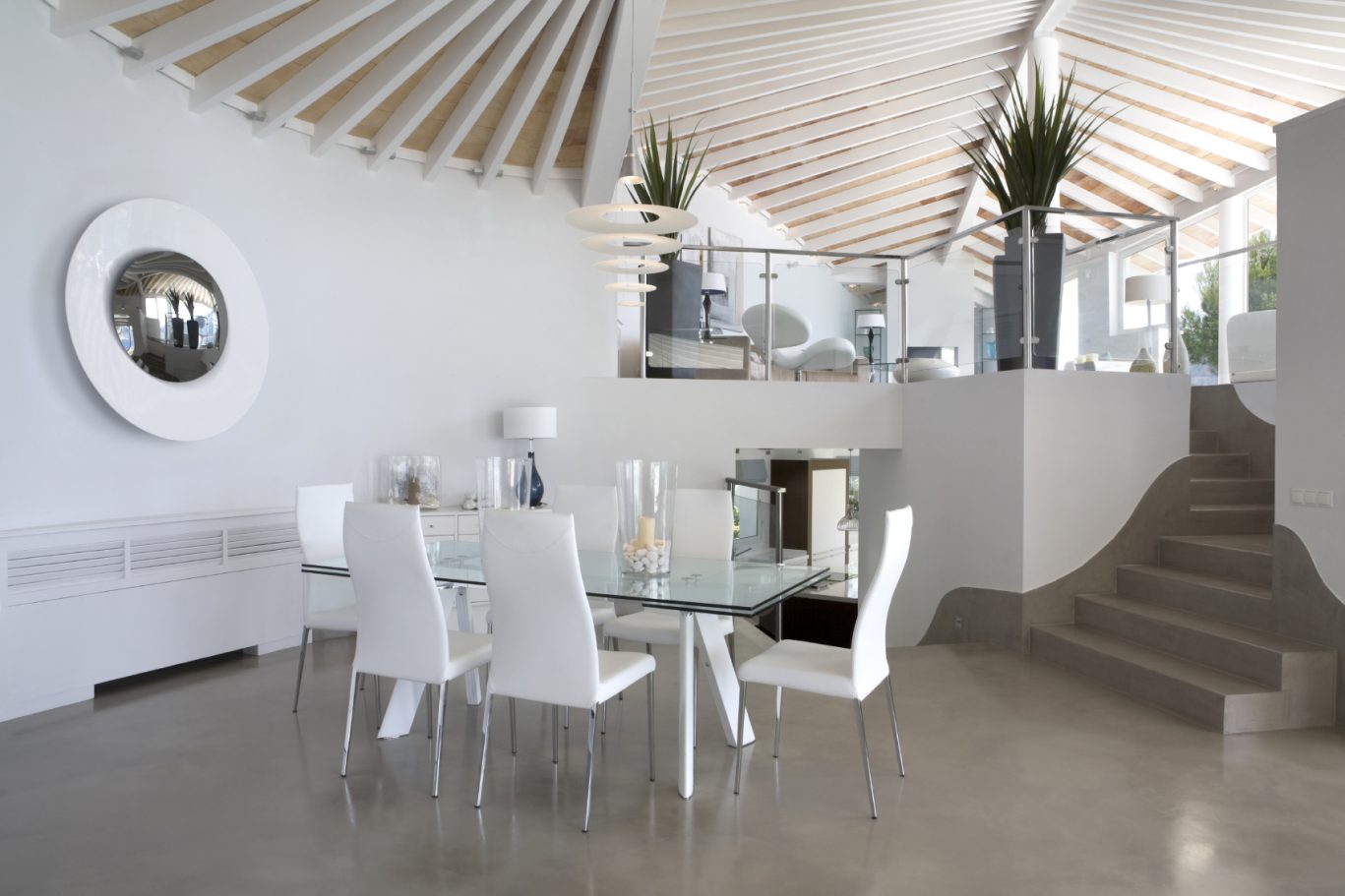 Moderne Küche mit Glasstisch, weißen Stühlen und offenem Raumdesign.